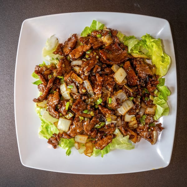 Yen Ching Express's black pepper beef with onions and scallions, served on a bed of lettuce.